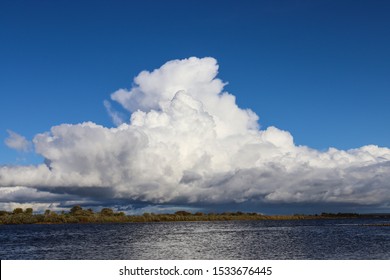 Large white cumulonimbus cloud, thunderstorm, over the Neman river