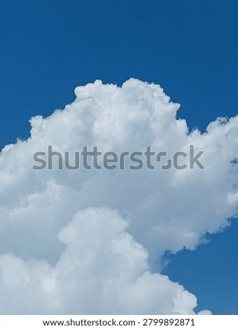 Large white cumulus cloud in a deep blue sky, beautiful cloudscape background with copy space for weather and nature concepts