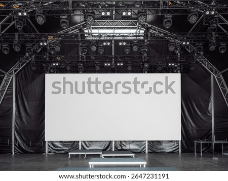 Large white LED screen or digital billboard mockup on a professional stage with lighting rigs and empty risers, ideal for showcasing custom visuals, branding, or event promotions in high resolution