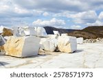 Large white marble blocks in an old abandoned quarry in the village of Buguldeika 
