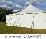 large white marquee tent side with a dramatic cloudy sky