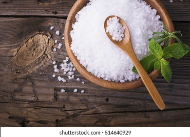 Large White sea salt in a natural wooden bowl with a sprig of fresh rosemary on a simple wooden background. Selective focus. room for text - Powered by Shutterstock