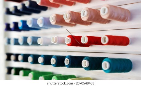 Large white stand with spools of multi-colored thread.