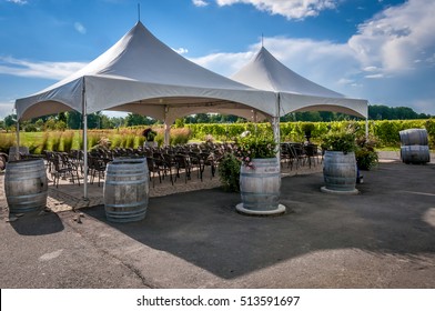 A large white wedding tent set up for an outdoor ceremony  or banquet on a vineyard