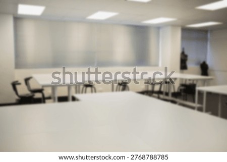 Large white worktable is being shown in flat design studio, with stools, chairs, mannequins. Classroom, collaborative, bright, minimalist, sewing, workspace, lighting