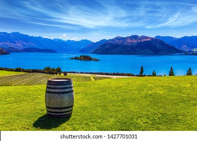  Large Wine Barrel Stands On The Lawn. Lake Wanaka. New Zealand, South Island. Adorable Lake With Turquoise Water. The Concept Of Active, Ecological And Photo Tourism