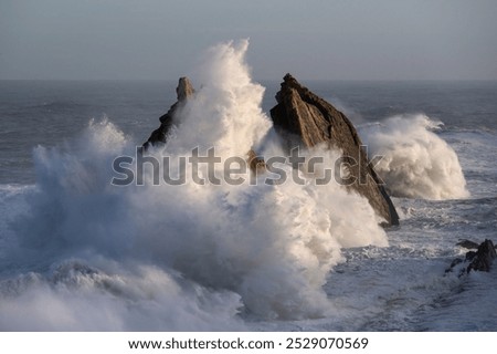 Large winter waves crash overy rocky coast, Playa de la Arnia, Spain