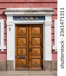 Large wooden door with the number 1 on the white door frame and the number 1805 (referring to the year of construction)above it