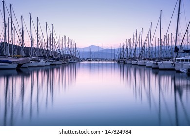 Large yacht harbor in purple sunset light, luxury summer cruise, sailboats in sunrise, leisure time, active life, vacation and holidays concept  - Powered by Shutterstock