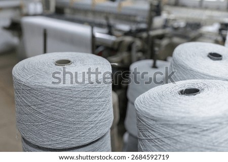 Large yarn spools in a textile workshop ready for weaving and spinning production showing industry machinery and quality manufacturing