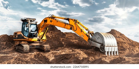 A large yellow crawler excavator moving stone or soil in a quarry. Heavy construction hydraulic equipment. excavation. Rental of construction equipment