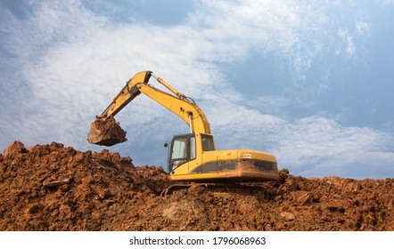Large yellow excavator digging on the mound - Shutterstock ID 1796068963
