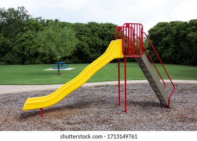 A large yellow and red slide at a playground area. 