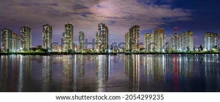 Large-format night panorama with a modern city over a reflection with a lake