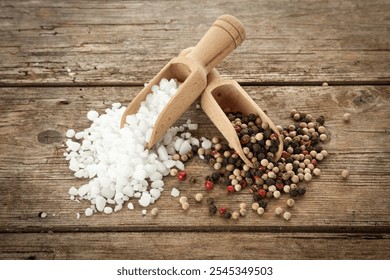 Large-grained salt and mixed peppercorns on wooden shovels, on rustic table, high angle view - Powered by Shutterstock