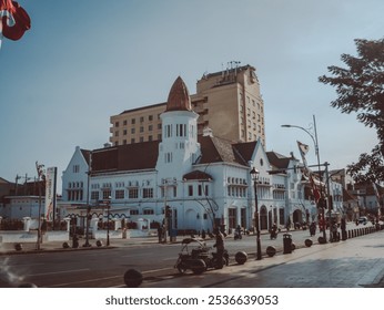 a larger historic colonial building beside a busy street during sunset, captures the essence of city life in a culture urban environment. - Powered by Shutterstock