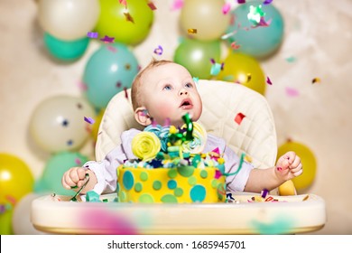 Large-scale portrait of a baby boy at a birthday party. Confetti from firecrackers and balloons around.