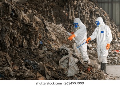 Large-Scale Waste Inspection: Environmental Experts in Hazmat Suits Working at a Massive Waste Pile. Focus on sustainable waste management, pollution control and safety.