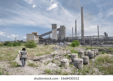 The Largest Air Pollutant In Dnipro Ukraine Is A Coke Chemical Plant. Flue Gas Stacks Emit Hundreds Of Tons Of Harmful Substances For Years Into The Atmosphere. Overweight Lady Goes By The Wasteland.