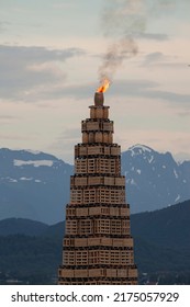 The largest bonfire in the world. Ålesund, Slinningsbålet. View of a burning top of a bonfire with a mountains in the background. Midsummer, equinox, summer solstice celebrations, festival.