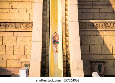 Largest Water Ride In Aqua Park In Dubai. Young Man Slides Down The Water Park In Dubai, Neptuns Ride. 