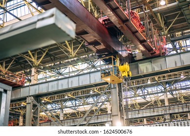 Large-tonnage industrial crane loading on factory background