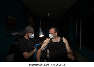 Larisa, Greece-June 6, 2020. A man is getting his hand tattooed by a tattoo artist. On June 01, tattoo shops in Greece reopened after months of coronavirus lockdown restrictions.