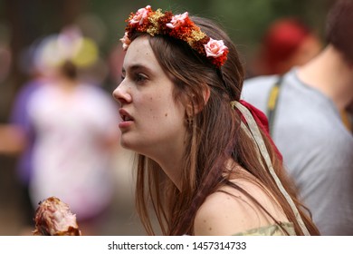 Larkspur, Colorado / USA - July 14, 2019:  Woman Eating A Turkey Leg At The Colorado Renaissance Festival Dressed In Historical Cosplay Outfit  