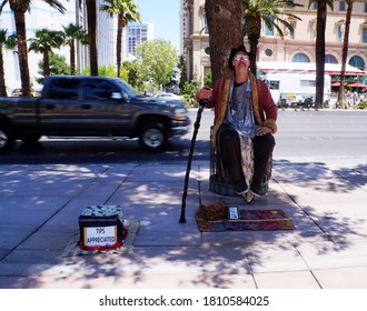 Las Vegas, Nevada - May 26, 2014. Street Performer Magician Sitting, Suspended In Air Holding A Cane. Street Artist.