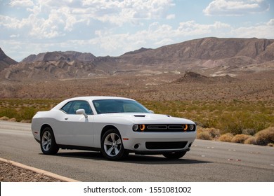 Las Vegas, Nevada, USA - July 2019: White Dodge Challenger With Mountain Desert Landscape In The Back.