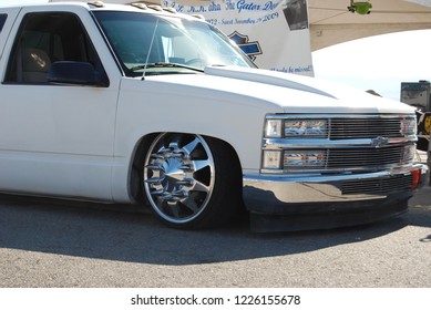 Las Vegas, Nevada/USA-Aug. 6, 2011: White Chevy Custom Low Rider Truck With Custom Spoked Wheels And Black Tinted Windows. Vehicle Is Positioned Next To Vendor Canopy Tent.