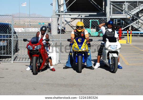 Las Vegas, Nevada/USA-August 6, 2011: Three\
African American bikers prepare to ride the custom sport bikes\
under their control with the Vegas Speedway Stadium in the\
background and a clear path\
ahead.