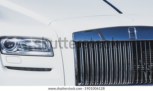 Las Vegas, NV, USA\
1-22-2021: Front of a Rolls-Royce Ghost zoomed in on the grille and\
right headlight. Captured in a minimalistic approach. 2011 model in\
white.