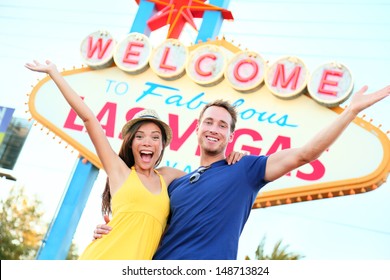 Las Vegas People - Couple Happy Cheering By Sign. Welcome To Las Vegas Sign Billboard And Excited Cheerful Young Multiracial Couple Having Fun On The Strip During Travel Holiday Vacation, Nevada, USA.