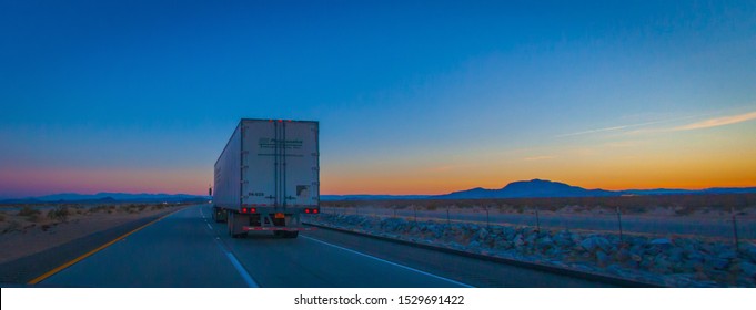 Las Vegas, United States - February 22 , 2013 : A truck driving in the desert during the evening night while the sunset over the desert from las vegas to los angeles