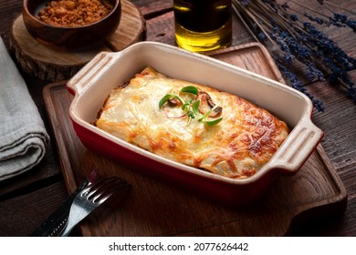 Lasagna with meat and tomato sauce baked in the oven in a ceramic dish. Homemade bolognese lasagna, rustic style