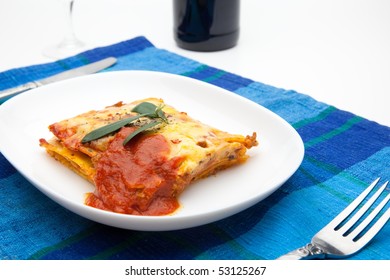 Lasagna On White Plate And Blue Table Mat