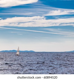 Laser Class Dinghy Sailing Across Blue Sea.