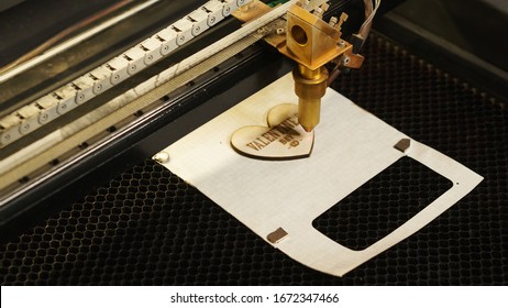 Laser cutting beam high precision on a plywood sheet. Modern technology of wood cutting. laser cut wooden 3d symbol of valentine's day. Industrial laser engraving. CNC laser. Masterclass, workshop