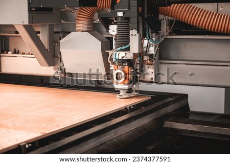 Laser cutting machine cutting the sheet of wood. Hi-technology manufacturing concept.