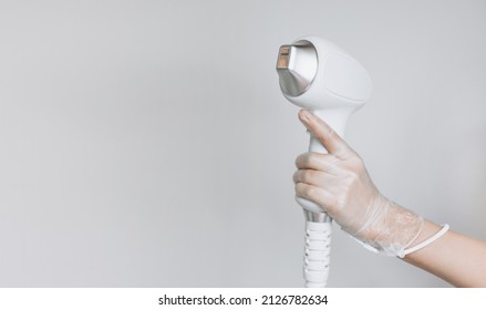Laser device for removing unwanted hair in the hand of nurse. Laser hair removal, cosmetic body treatments. Concept of hygiene, beauty, health. Girl holding a working part of the epilator in her hand - Shutterstock ID 2126782634