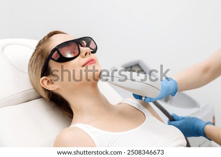 Laser hair removal procedure in an aesthetic clinic, focusing on facial hair removal from a female patient. Highlights advanced technology in hair removal and personalized skincare.
