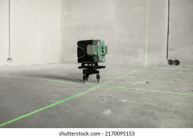 Laser level, construction, finishing work in the room. Laser building level with green beams on the wall bare cement of the house - Shutterstock ID 2170095153