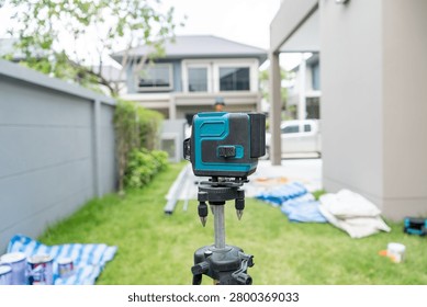 Laser level in different angles with three legs for renovation at the village, outdoors background.