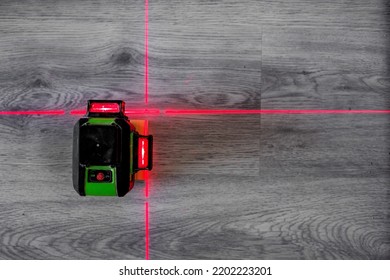 Laser Level With Red Beams. Construction Work Indoors. Laminate Laying. View From Above