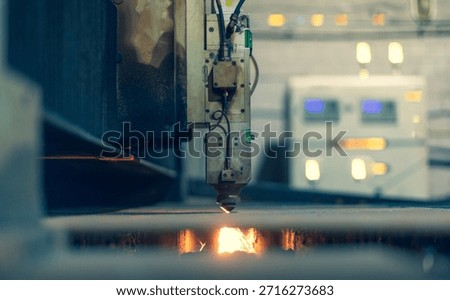 A laser machine with software cuts metal against the background of an electronic control center. A lot of glowing buttons and indicators on the laser control panel. High quality photo