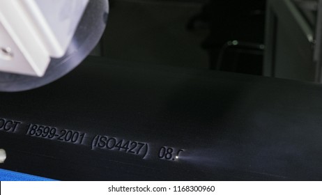 Laser Marking Machine Engraving. Manufacture of plastic water pipes of the factory. Process of making plastic tubes on the machine tool with the use of water and air pressure.