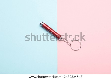 Laser pointer flashlight on pink blue background