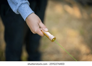 A laser pointer with a green glow. The image of a man with a green laser pointer.Laser blinding.Dangerous teen games.