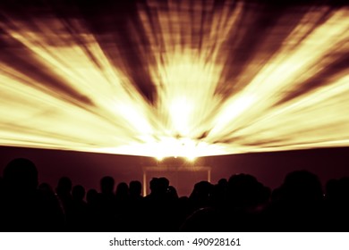 Laser show rays in fire red yellow and orange party colors. Best visual show with a crowd silhouette and great laser rays for e.g. an illustration background of an invitation flyer